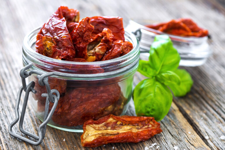 Sun dried tomatoes on wooden background