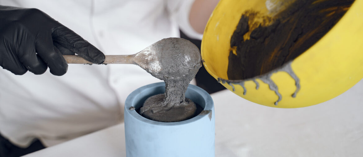 Man works with a cement. Concrete cement grey pot. Hand made concrete planters for succulents and cacti.