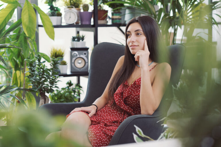 Woman relaxing in a room with many plants